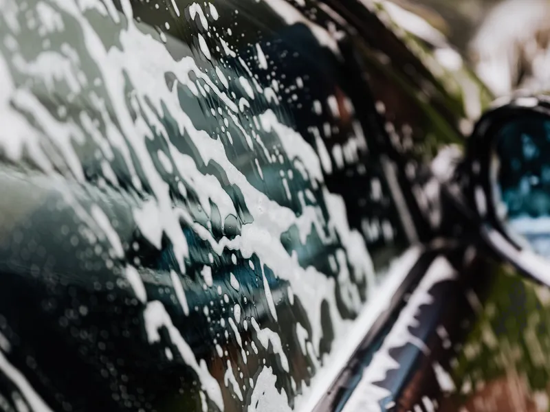 Mousse de lavage sur la vitre d'une voiture